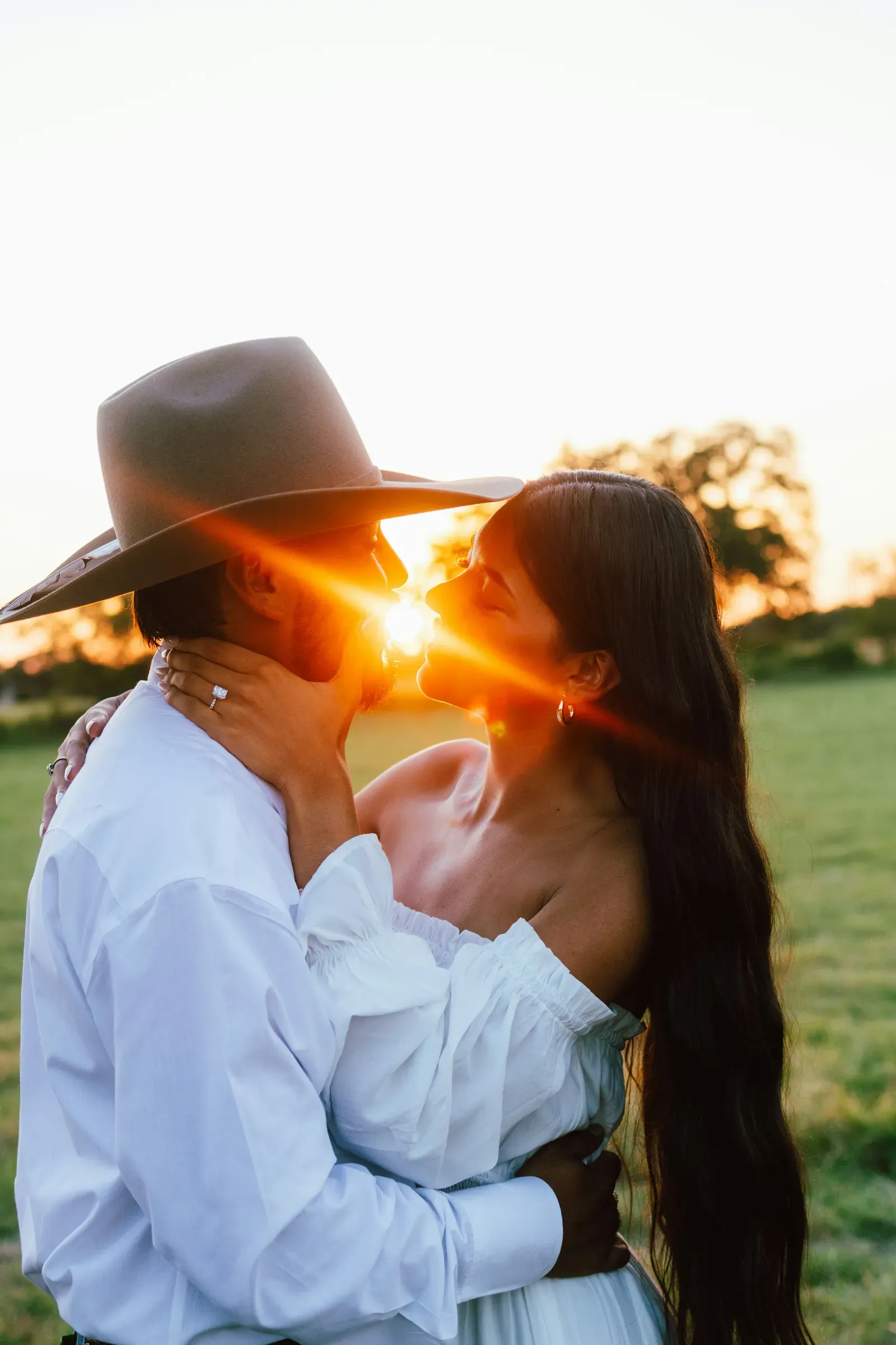 Just after she said yes — a kiss straight into the setting sun, his hat brim catching the flare.