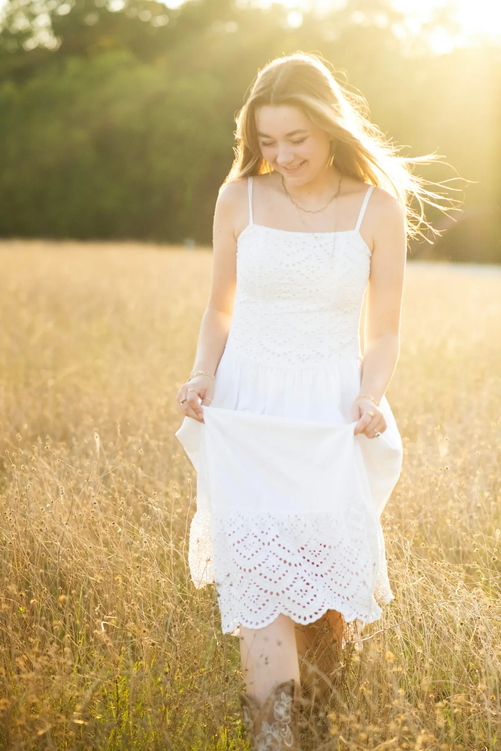 Walking the field's edge, the hem of her dress trailing the seedheads.