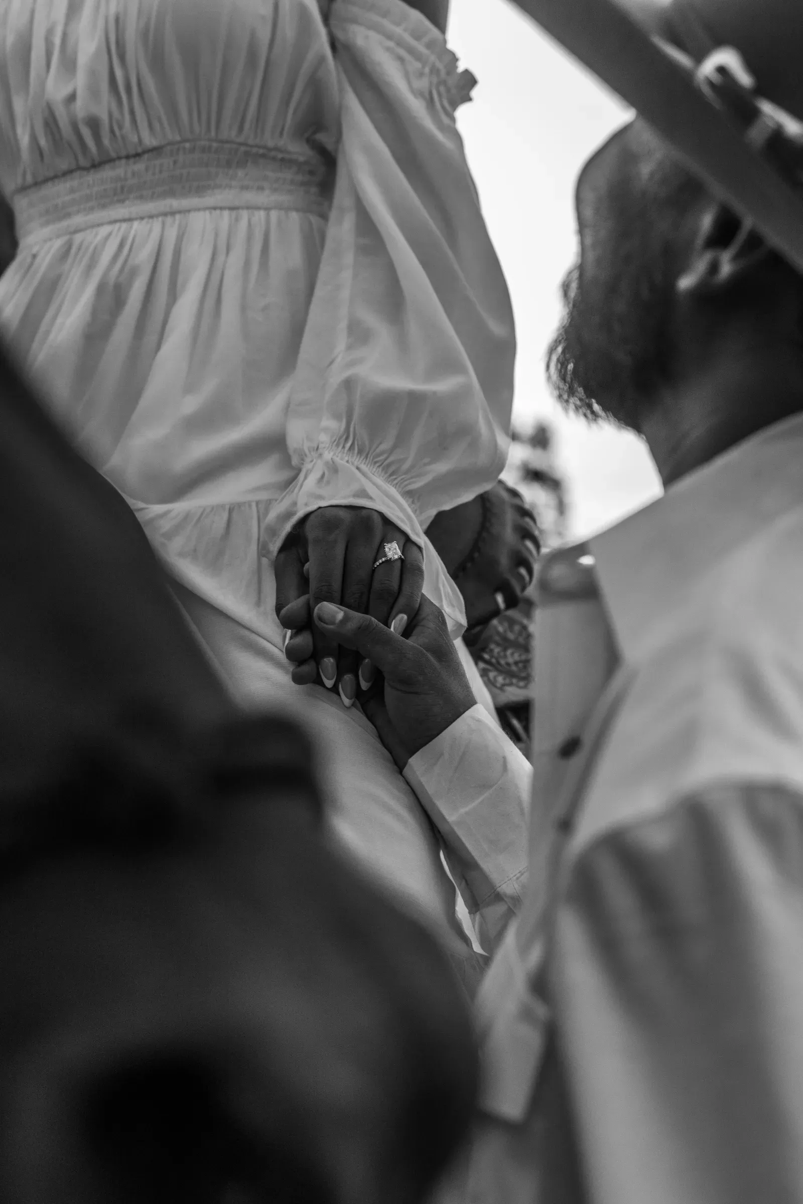 Her hand resting in his, the new ring front and center, in black and white.