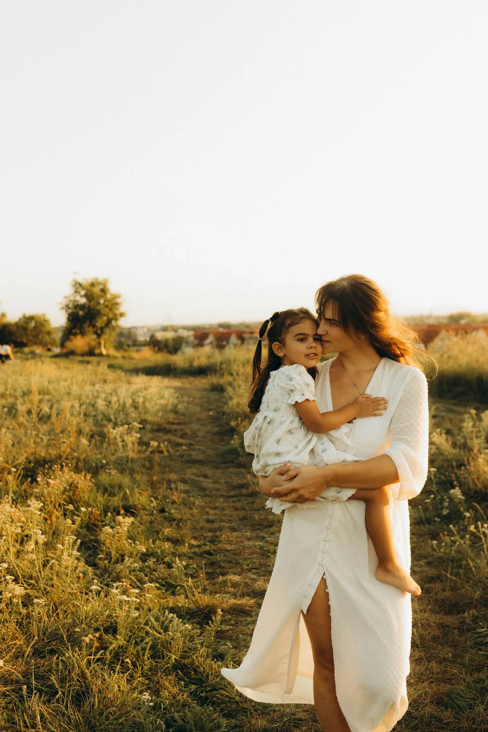 Carried home on Mom's hip along the dirt path at dusk.