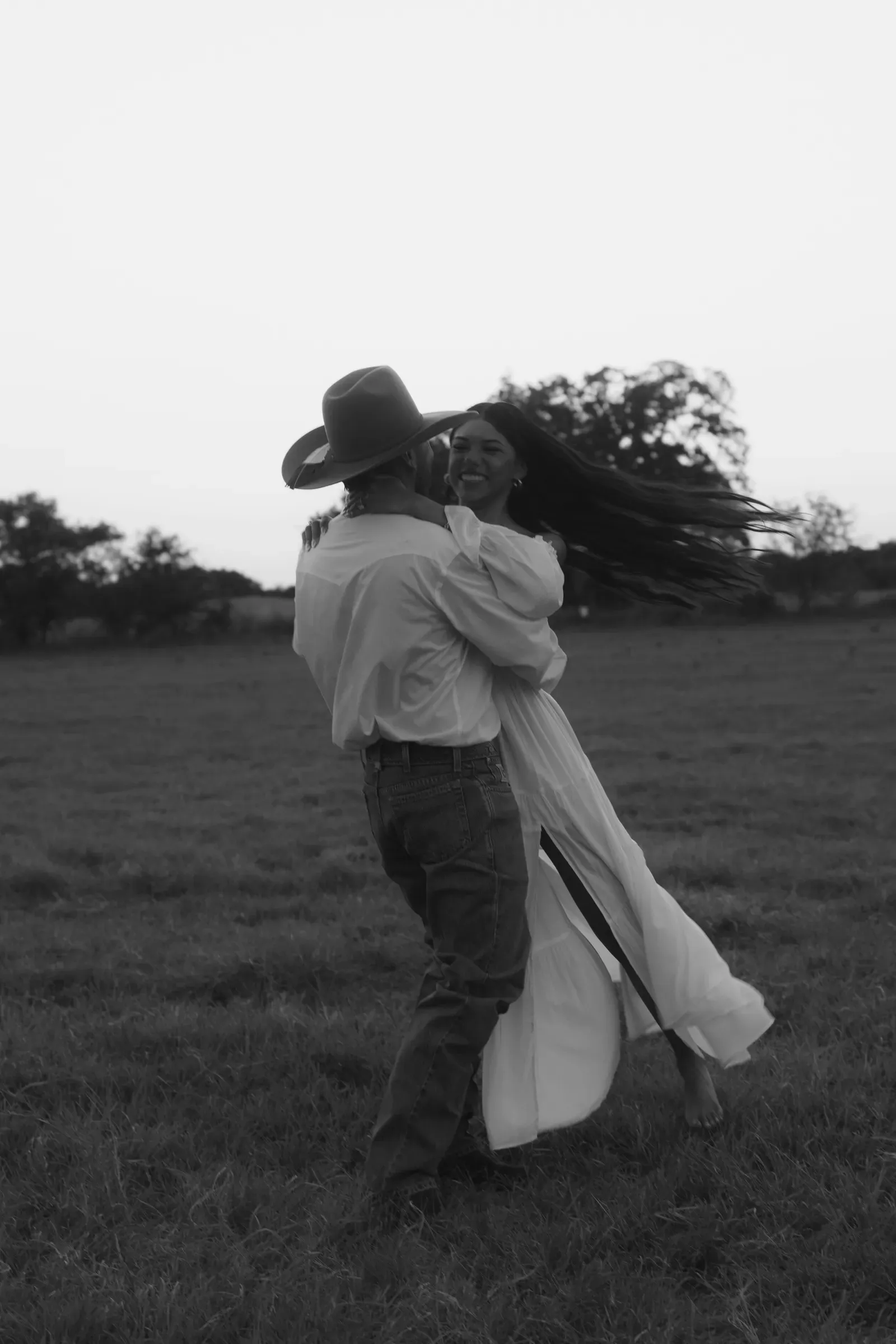 He spins her through the dusk, her hair flying, photographed in black and white.